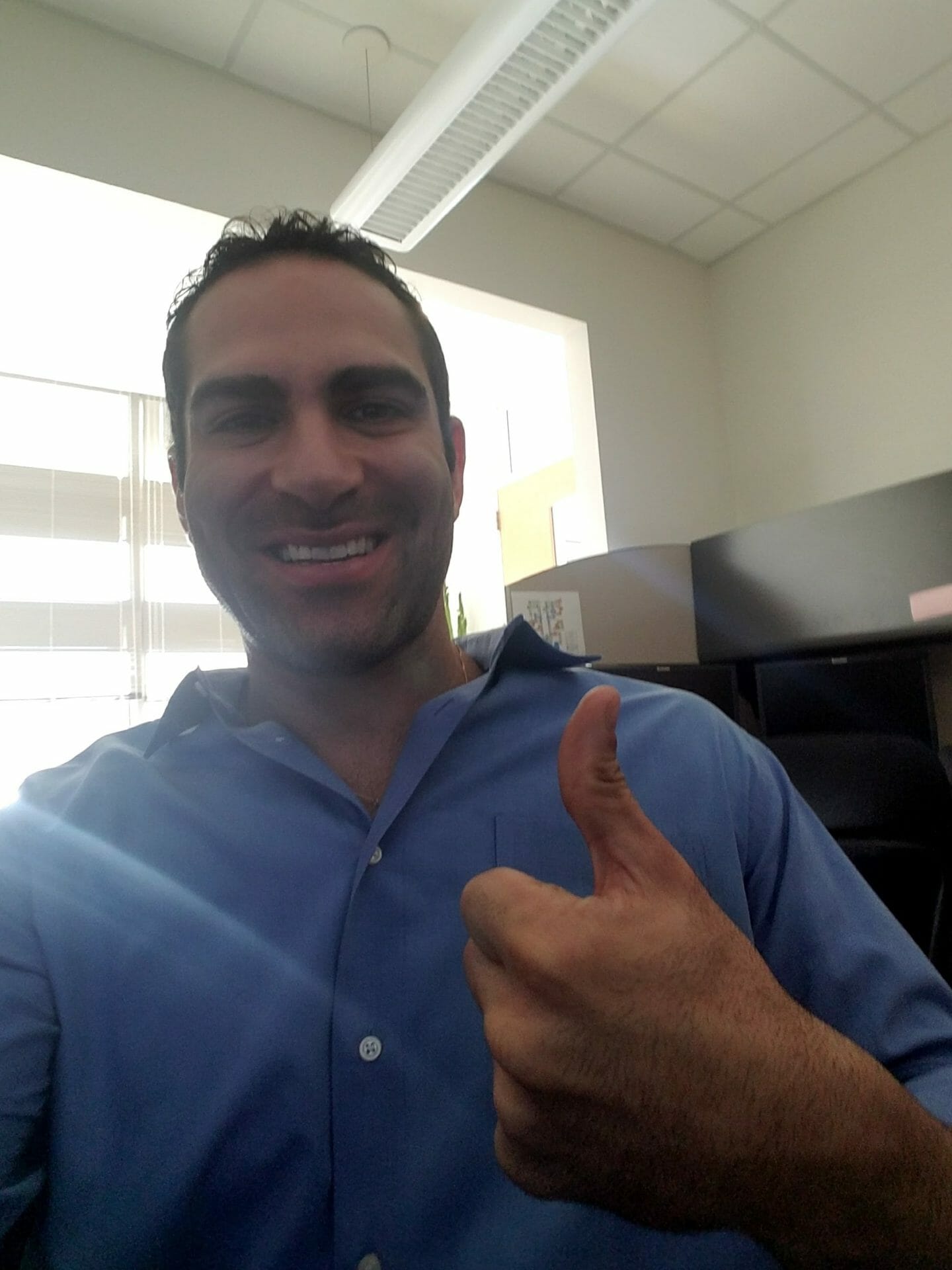 Israel Joffe smiling and giving a thumbs-up in an office